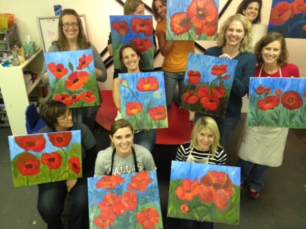 Group of women holding flower paintings