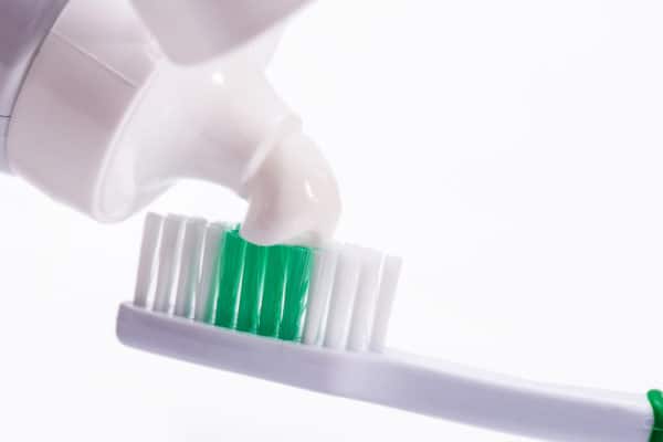 Toothpaste being applied to toothbrush